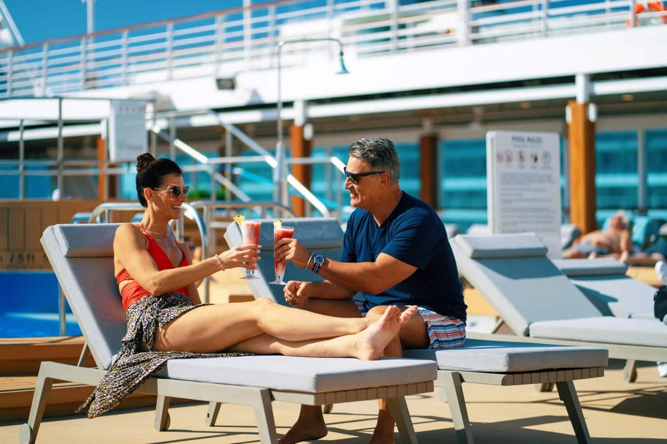 Guests enjoying cocktails beside the onboard pool