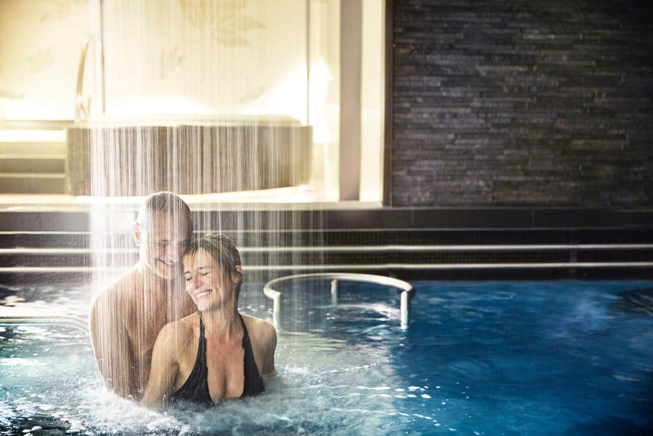 Couple relaxing under a cascading hydrotherapy shower at the Lotus Spa