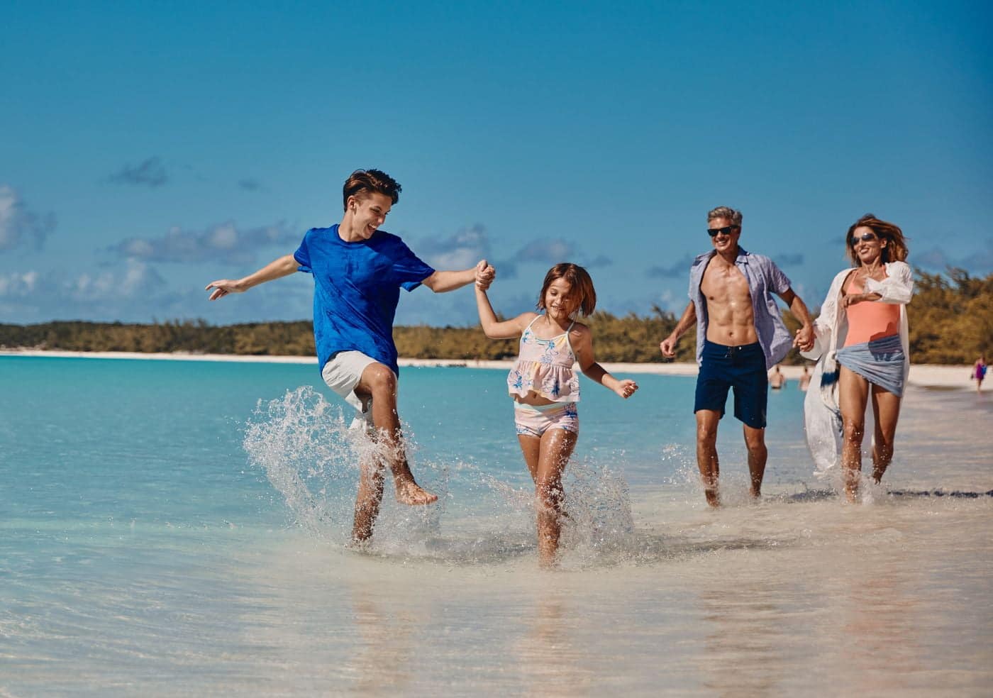 Family walking along Half Moon Cay beach