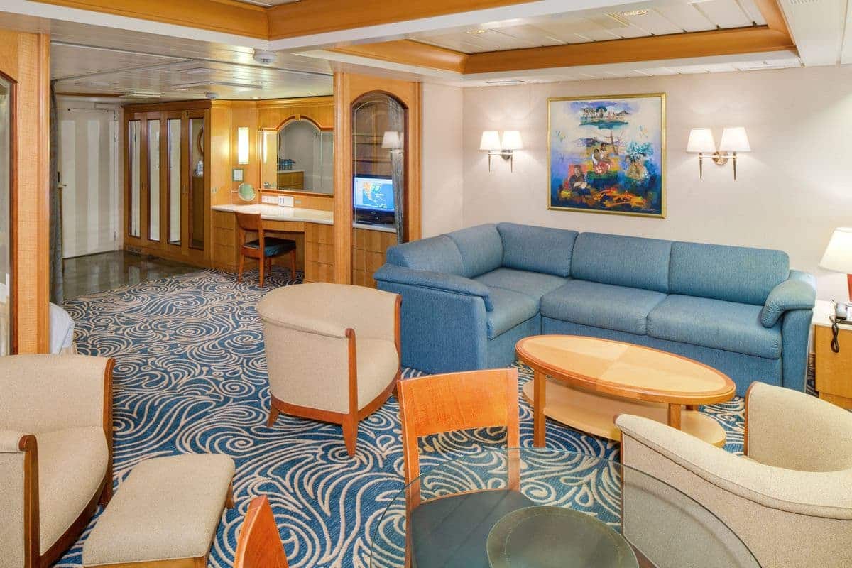 Owner’s Suite living room on Enchantment of the Seas with sofa chairs and modern décor