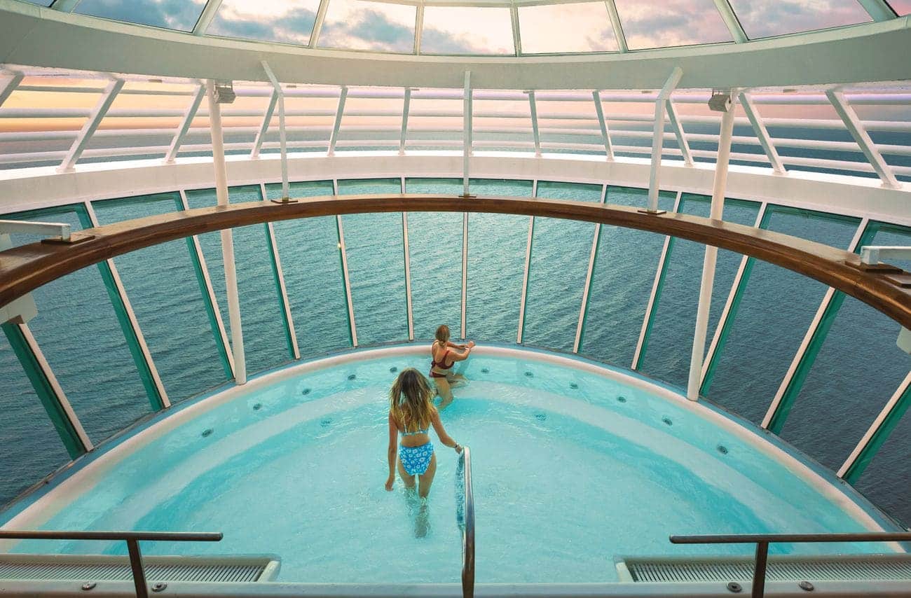 Whirlpool overlooking the ocean on Allure of the Seas with guests relaxing at sunset