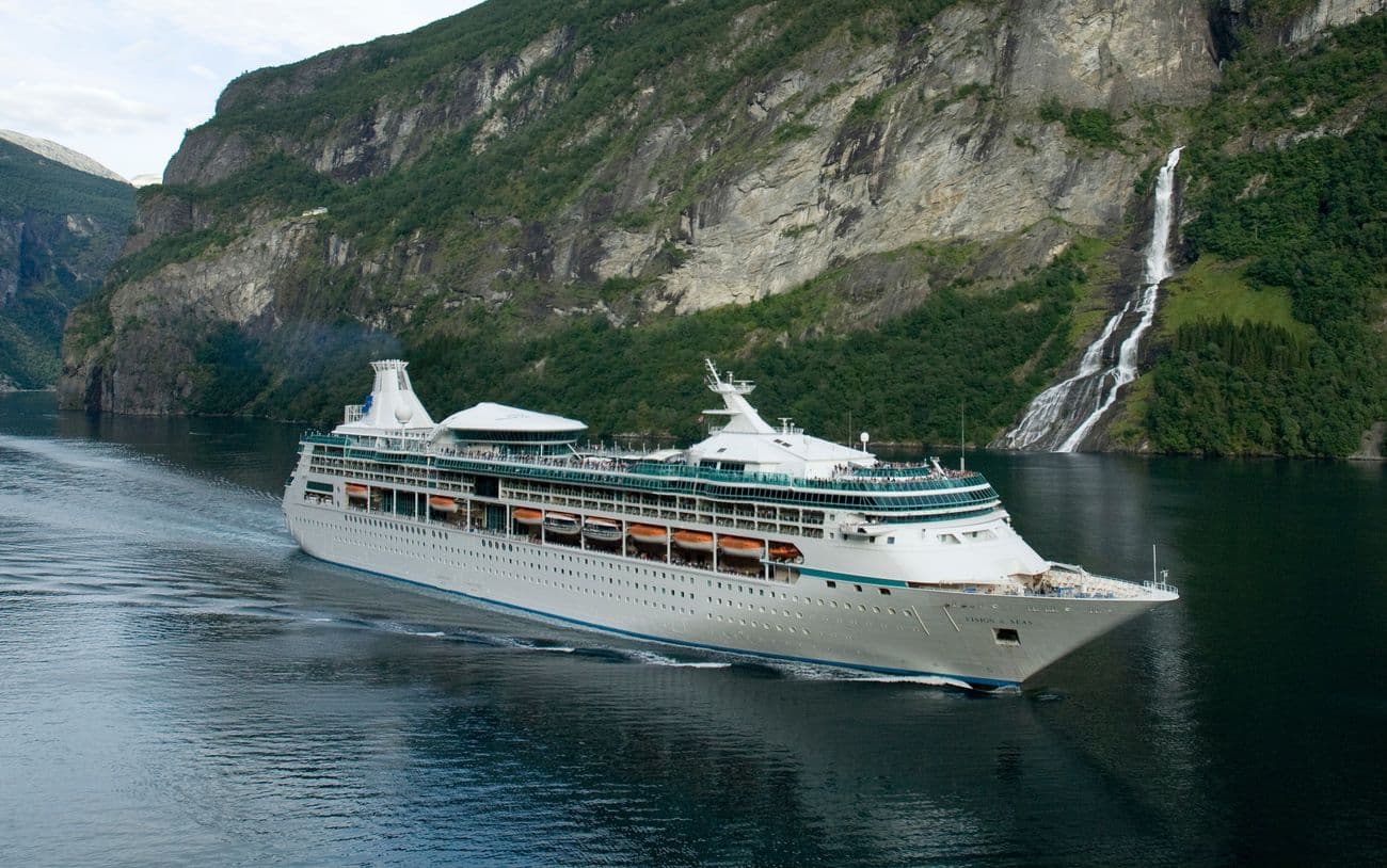 Vision of the Seas sailing through Norway’s Geirangerfjord near a waterfall