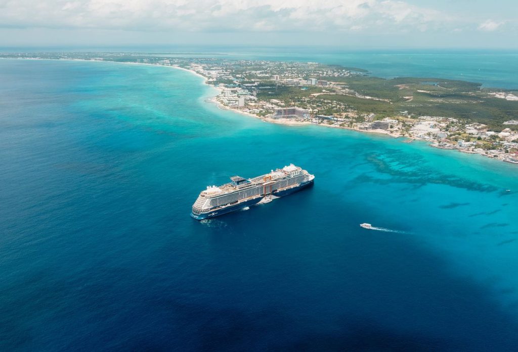 Celebrity Ascent anchored off the Caribbean coast with turquoise waters and tropical shoreline