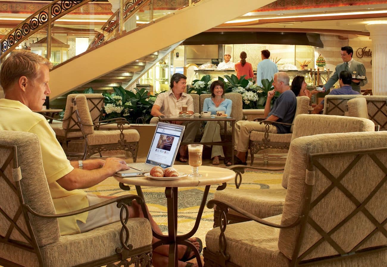 Piazza atrium on Crown Princess with lounge seating and guests enjoying coffee
