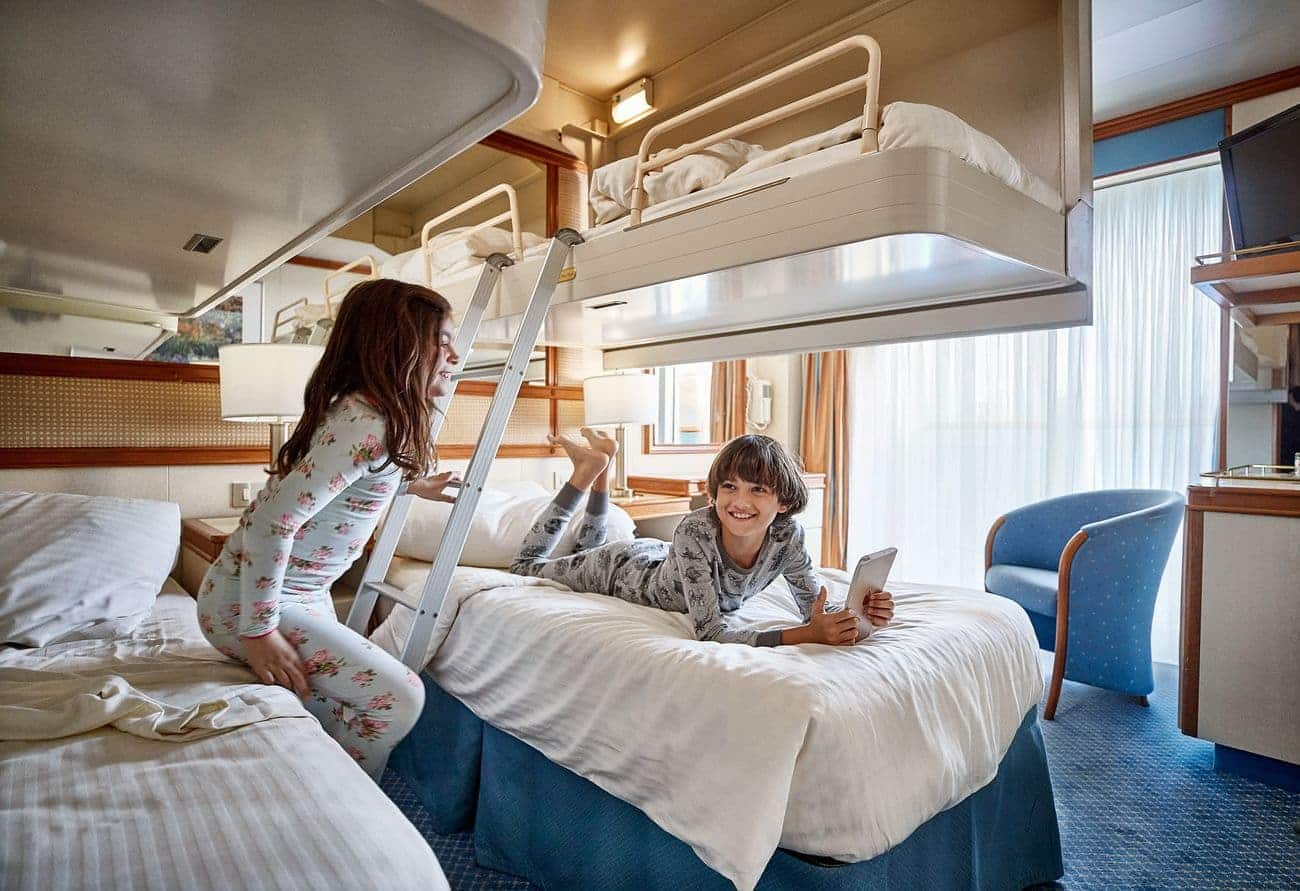 Balcony stateroom with twin beds, ladder bunks, and natural light