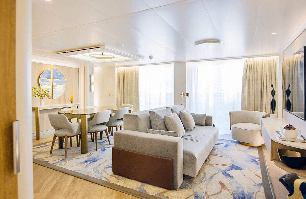 Spacious Sky Suite living area on Sun Princess with modern furniture and sea-view windows