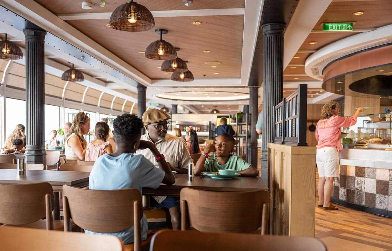 Families dining inside Marceline Market on Disney Wish surrounded by warm wood finishes large windows and casual food stations