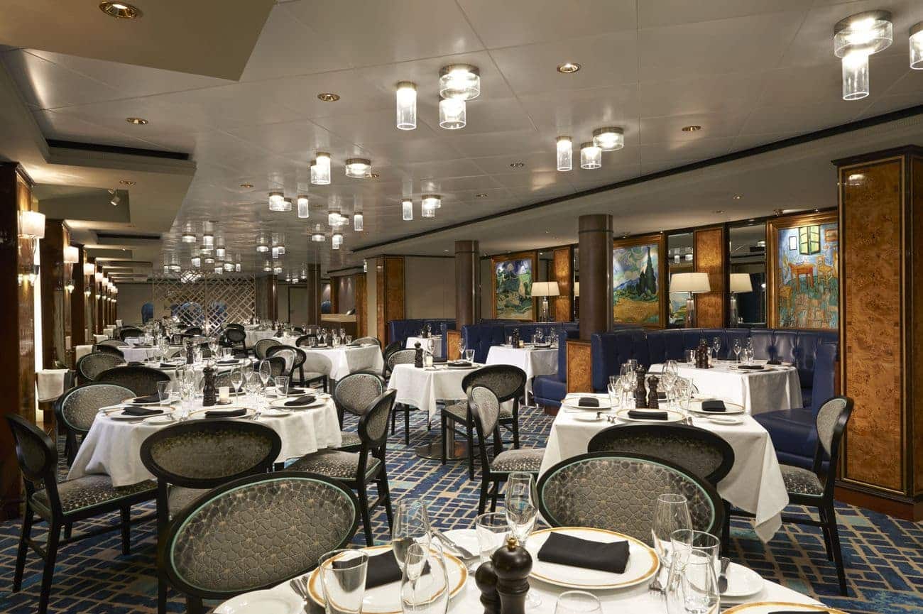 Le Bistro restaurant set with white tablecloths, upholstered seating, and warm ambient lighting