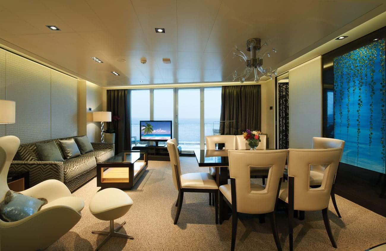 Deluxe Owner’s Suite living room on Norwegian Getaway with ocean-view windows