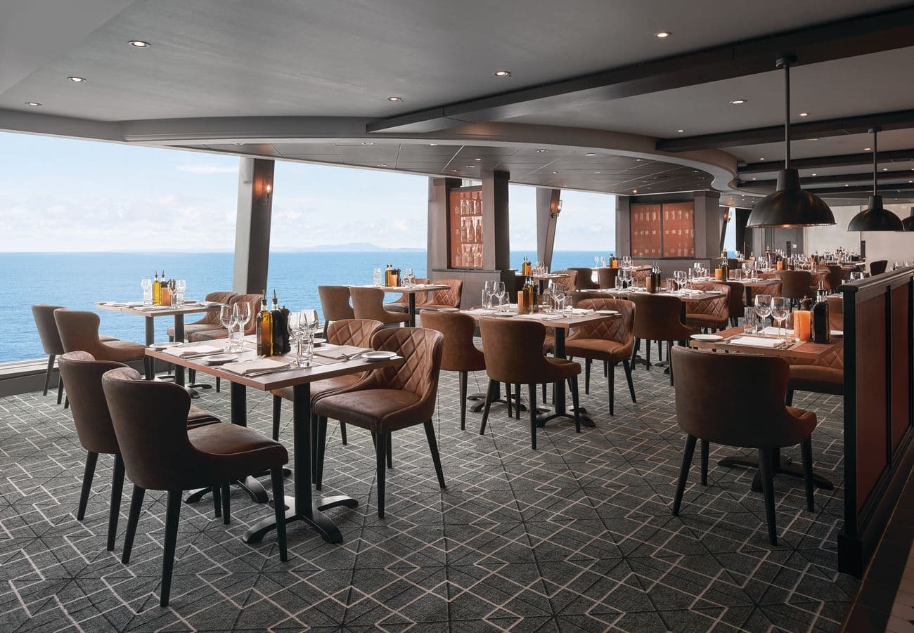 La Cucina Italian restaurant aboard Norwegian Sky with ocean views, set tables, and warm contemporary décor