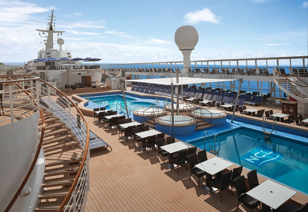 Pool deck with main swimming pool, whirlpools, sun loungers, and open sea views