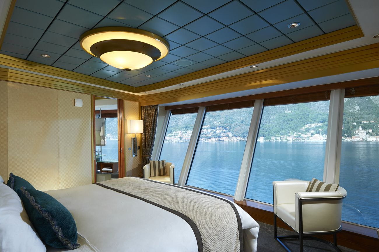 Garden Villa suite bedroom with floor-to-ceiling windows overlooking the sea