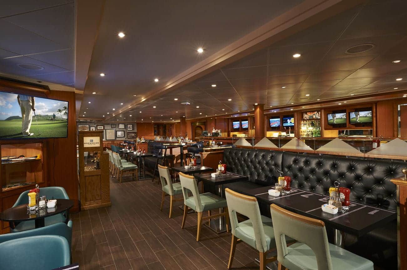 Sports bar aboard Norwegian Sun with dining tables, televisions, and casual seating