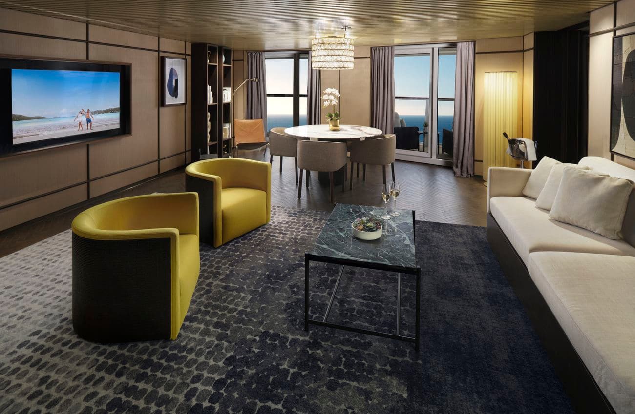 Haven Deluxe Owners Suite living and dining area aboard Norwegian Viva with balcony access
