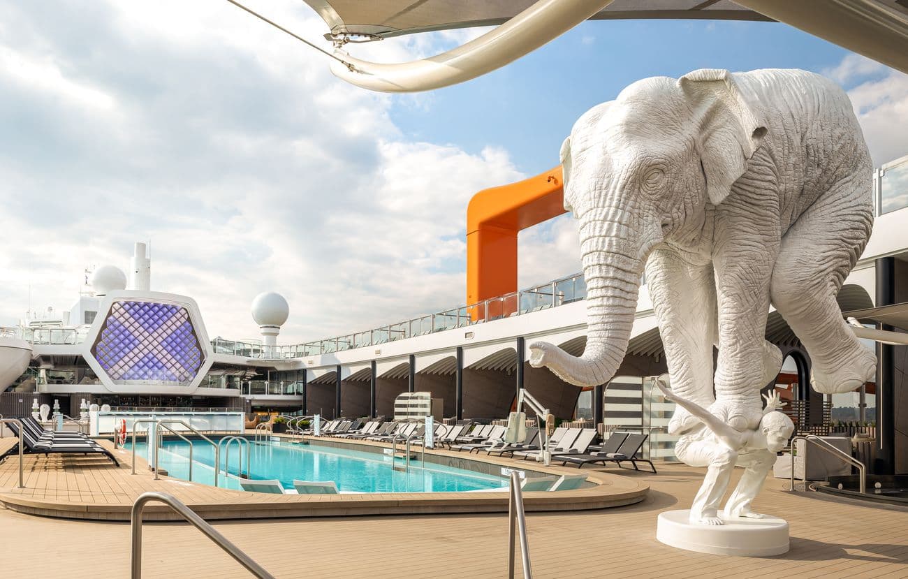 Resort-style pool deck on Celebrity Beyond with loungers and modern sculptures