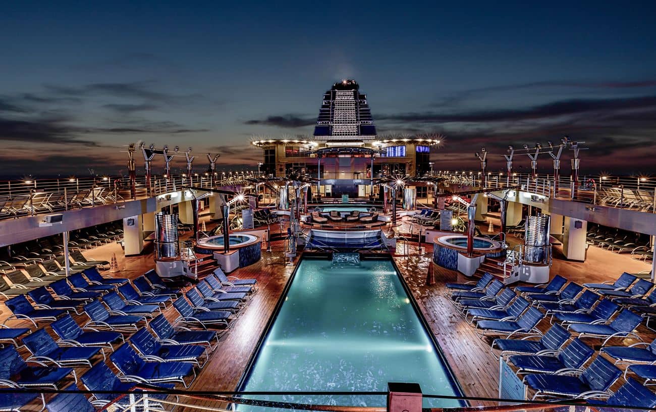 Evening view of pool deck illuminated at sea