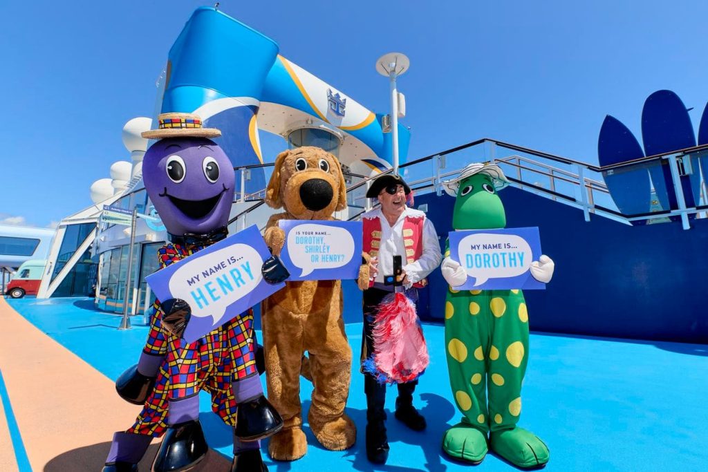 Wiggly Friends holding name signs on the cruise ship deck
