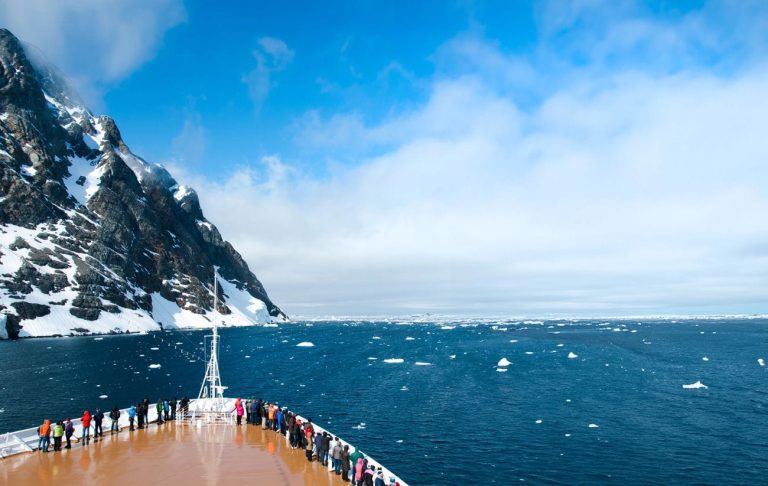 Nieuw Amsterdam Scenic Cruises Expand South America and Antarctica Exploration in 2027–2028 Guests on deck during Nieuw Amsterdam scenic cruises in Antarctica viewing icy coastline