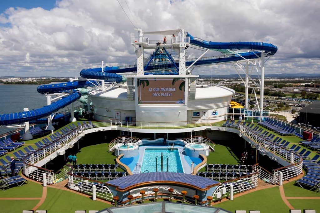 WaterWorks upper deck with twisting blue slides, pool area, sun loungers and large outdoor screen