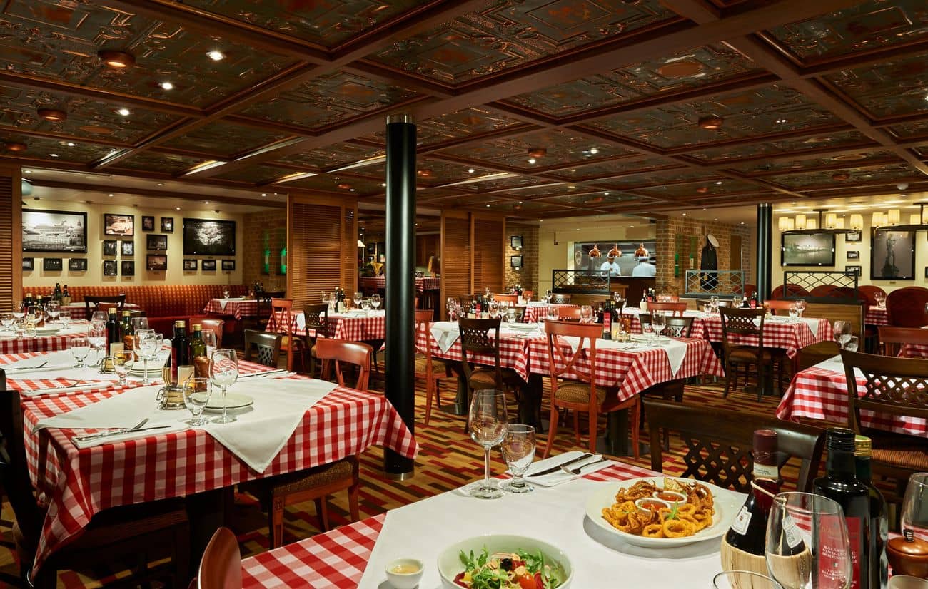 Carnival Horizon Cucina del Capitano restaurant with classic Italian decor, red checkered tables, and warm ambient lighting