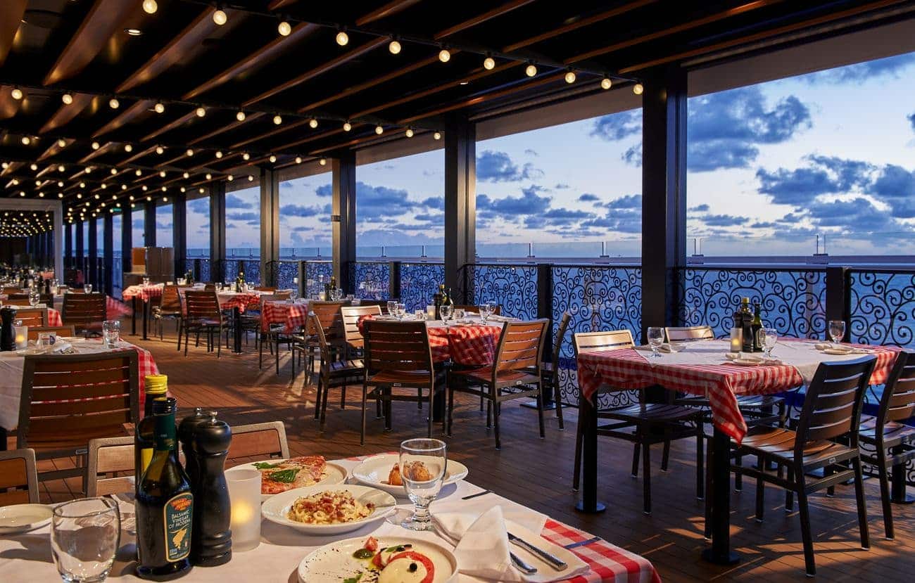 Cucina del Capitano outdoor terrace restaurant with ocean views and string lights aboard Carnival Mardi Gras