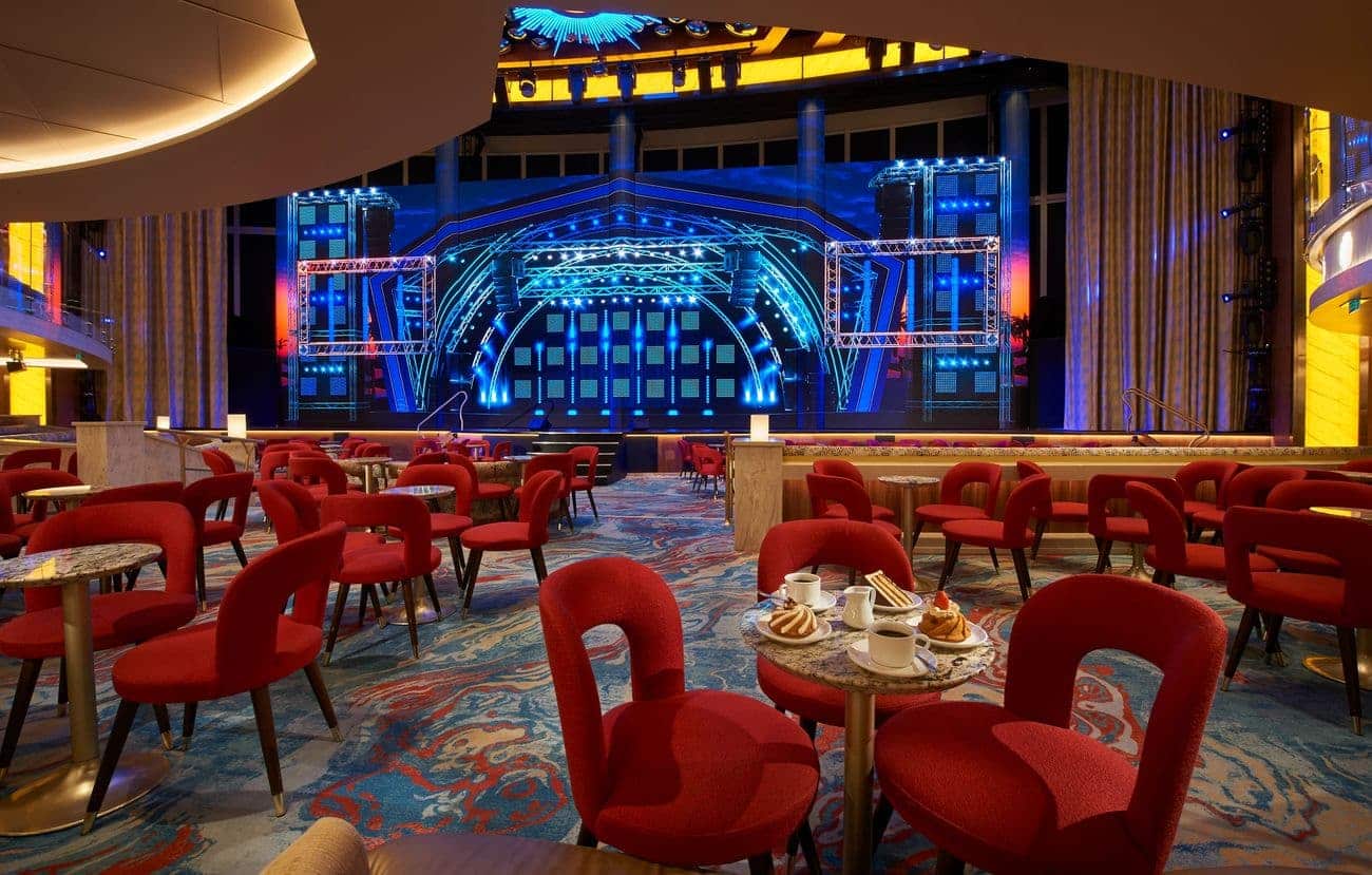 Grand Central multi deck atrium lounge with stage seating and large LED screens aboard Carnival Mardi Gras