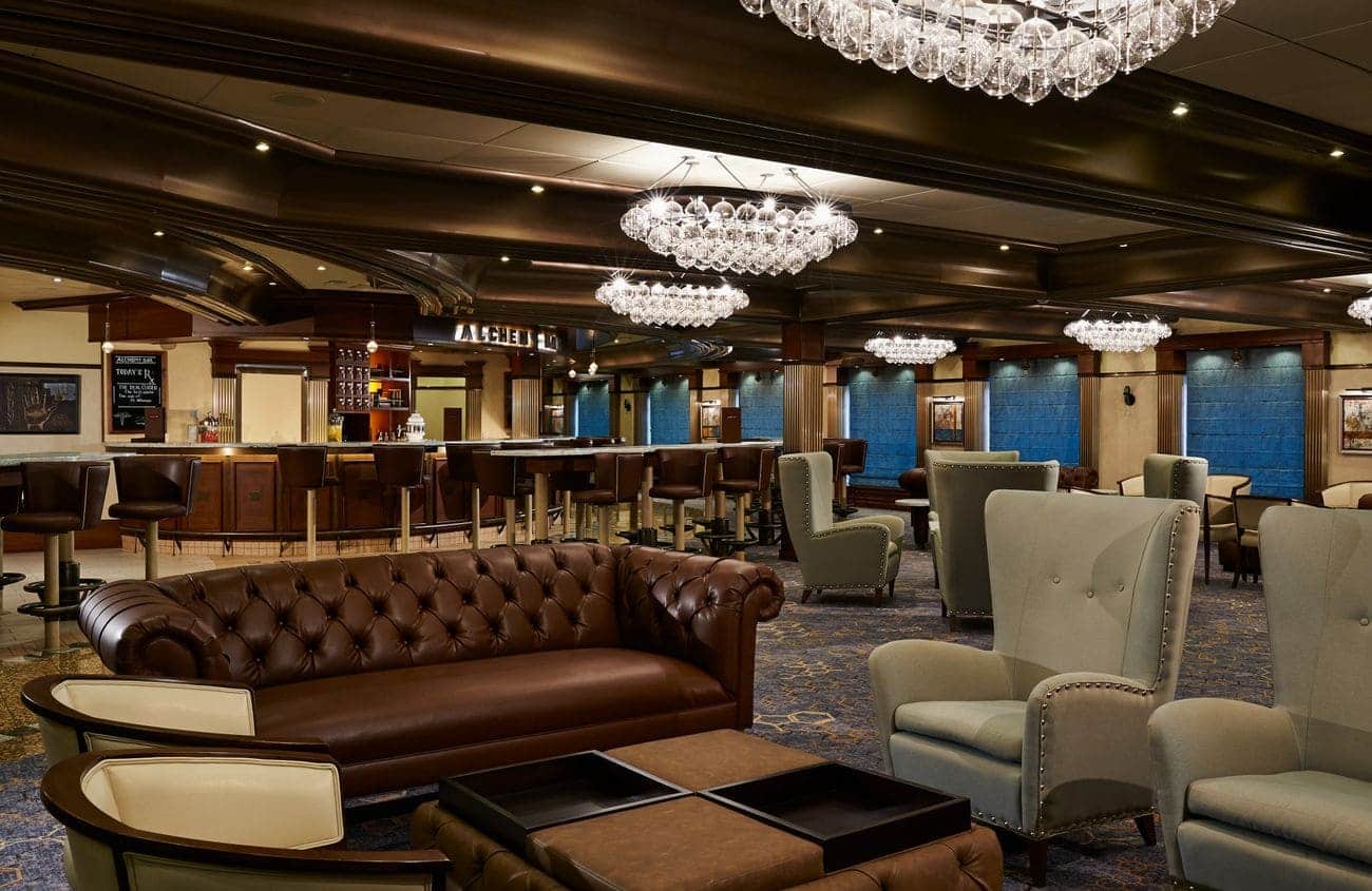 Elegant ship lounge with chandeliers, leather sofa, and bar seating