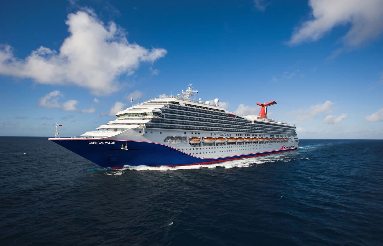 Carnival Valor sailing at sea under a bright blue sky