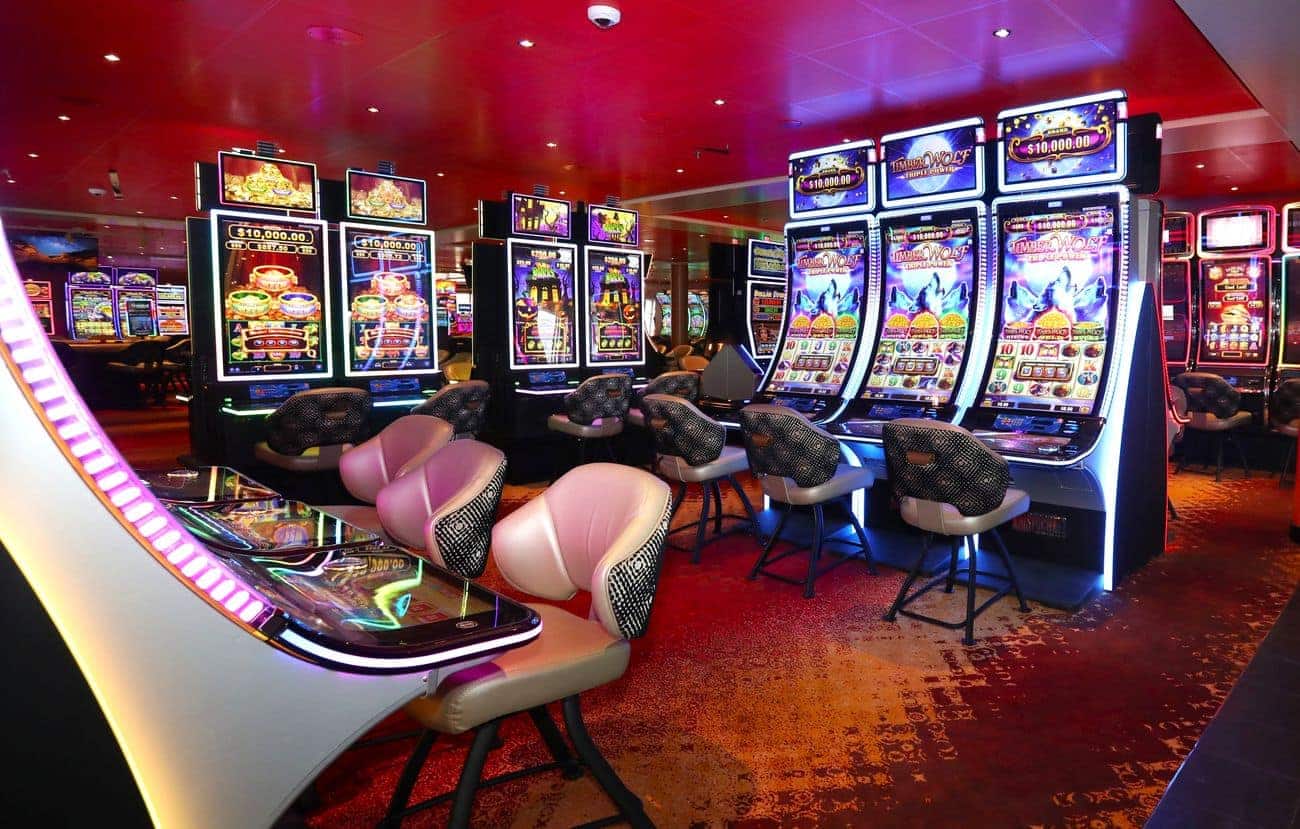 Casino floor with illuminated slot machines and gaming chairs