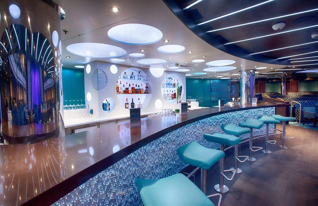 Contemporary bar with illuminated counter and teal stools
