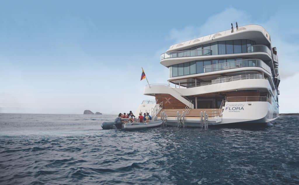 Expedition ship cruising through the Galapagos as guests approach the coast by Zodiac during Galapagos expedition sailings