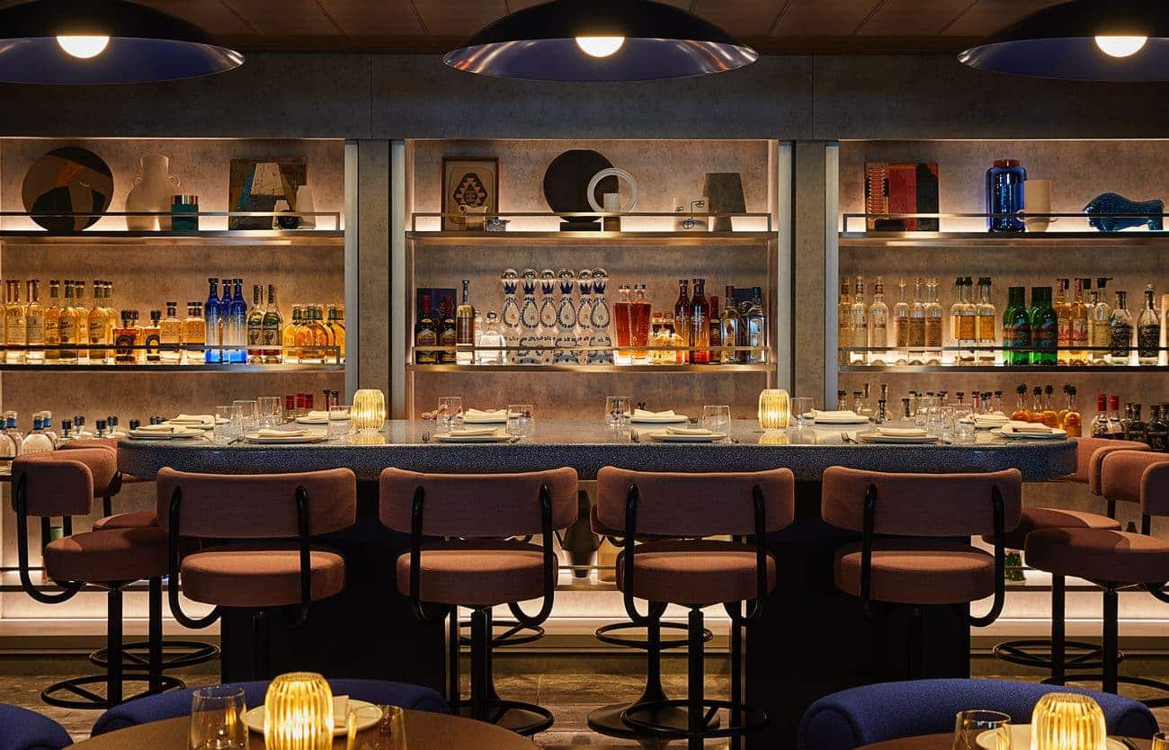 Pink Agave restaurant aboard Resilient Lady with illuminated bar shelves and modern seating