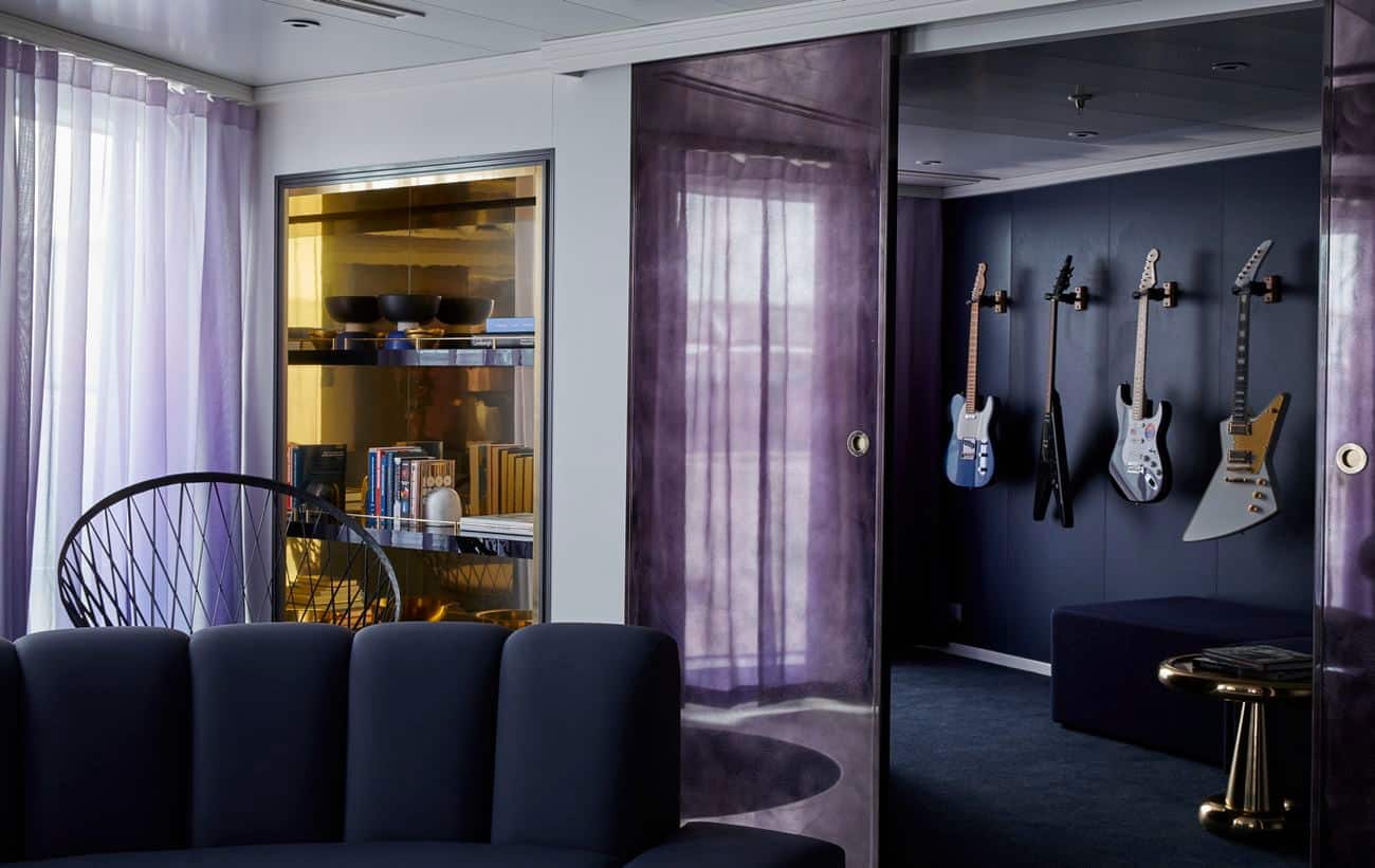 Rockstar Quarters suite living area with mounted guitars, velvet seating, and modern décor