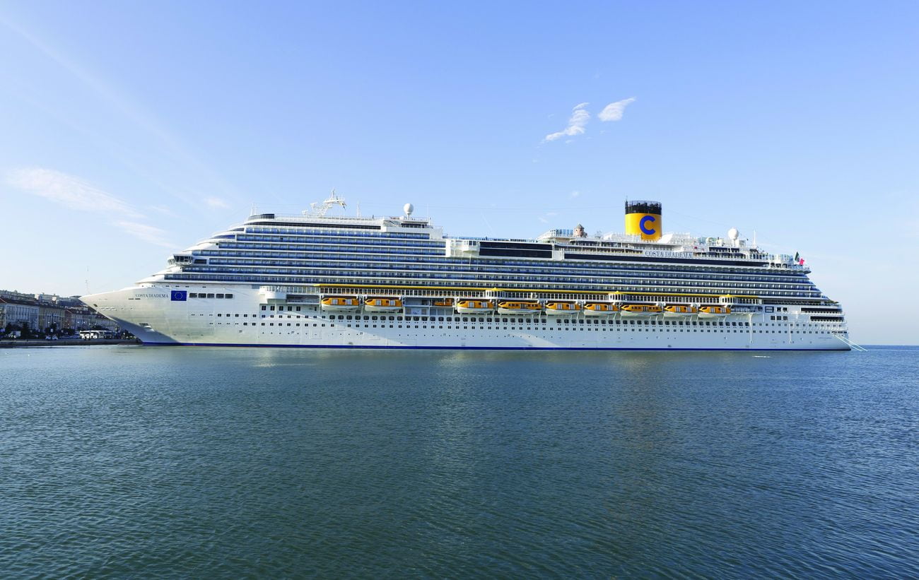 Costa Diadema docked in Trieste, Italy, viewed broadside across calm water.