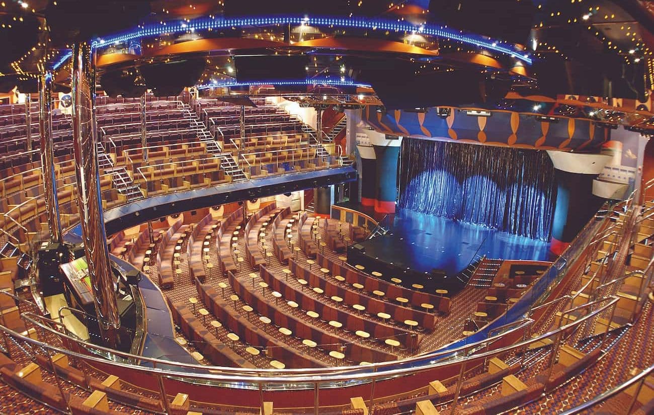 Costa Fortuna Rex Theatre with sweeping tiered seating and a blue-lit stage viewed from above.