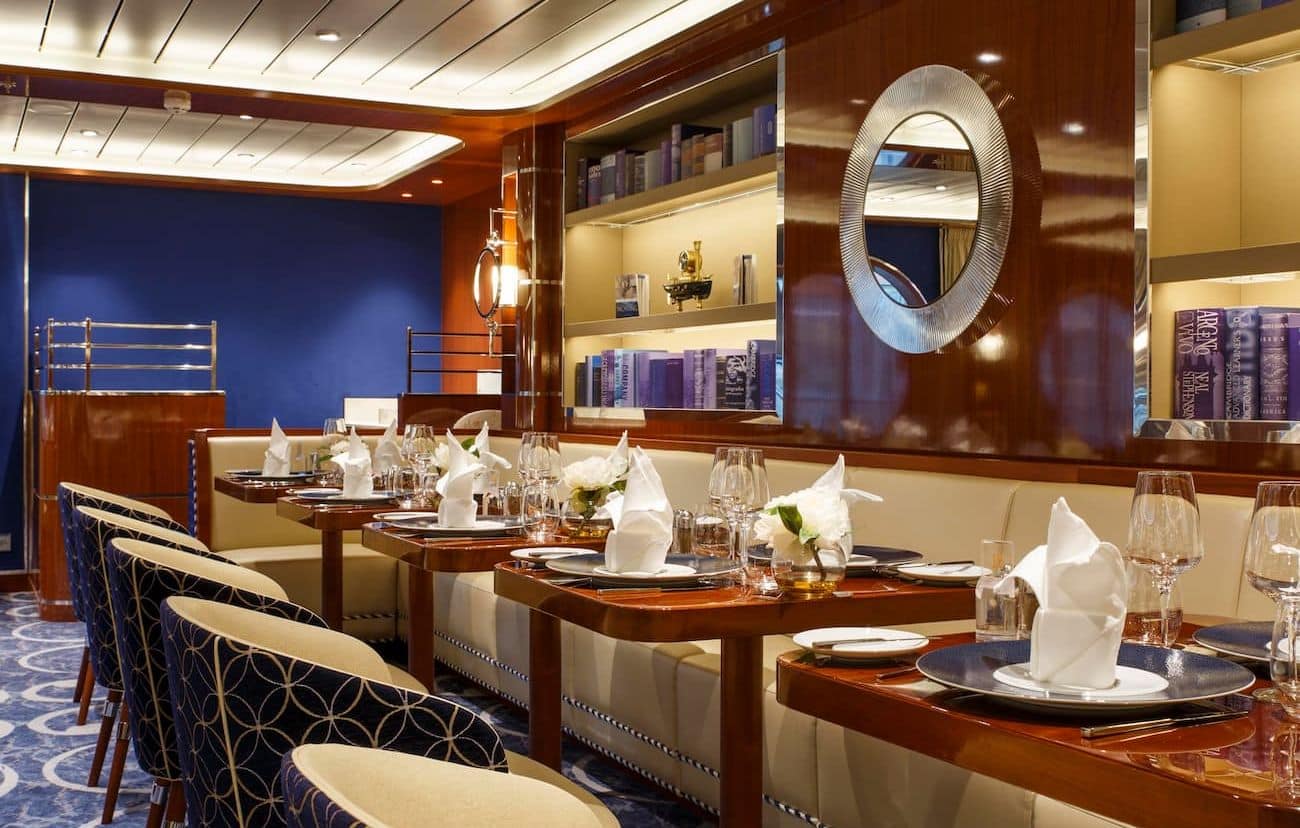 Costa Smeralda Bellavista Restaurant with neatly set tables, blue accents, and polished wood paneling.