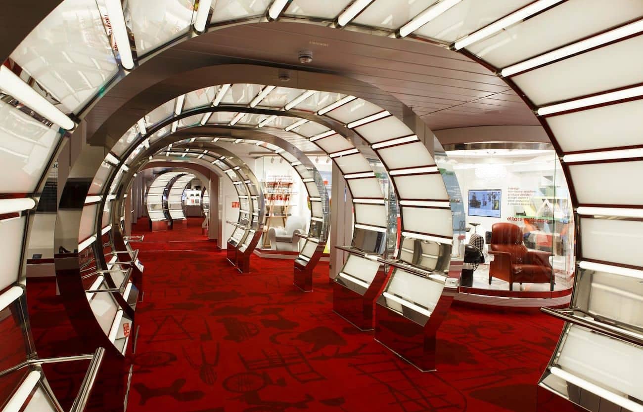 Costa Smeralda CoDe Museum corridor with glowing archways, red carpeting, and exhibition spaces along the sides.