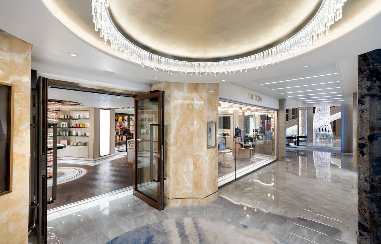 Oceania Allura Boutique entrance with polished marble, glass storefronts, and chandelier lighting
