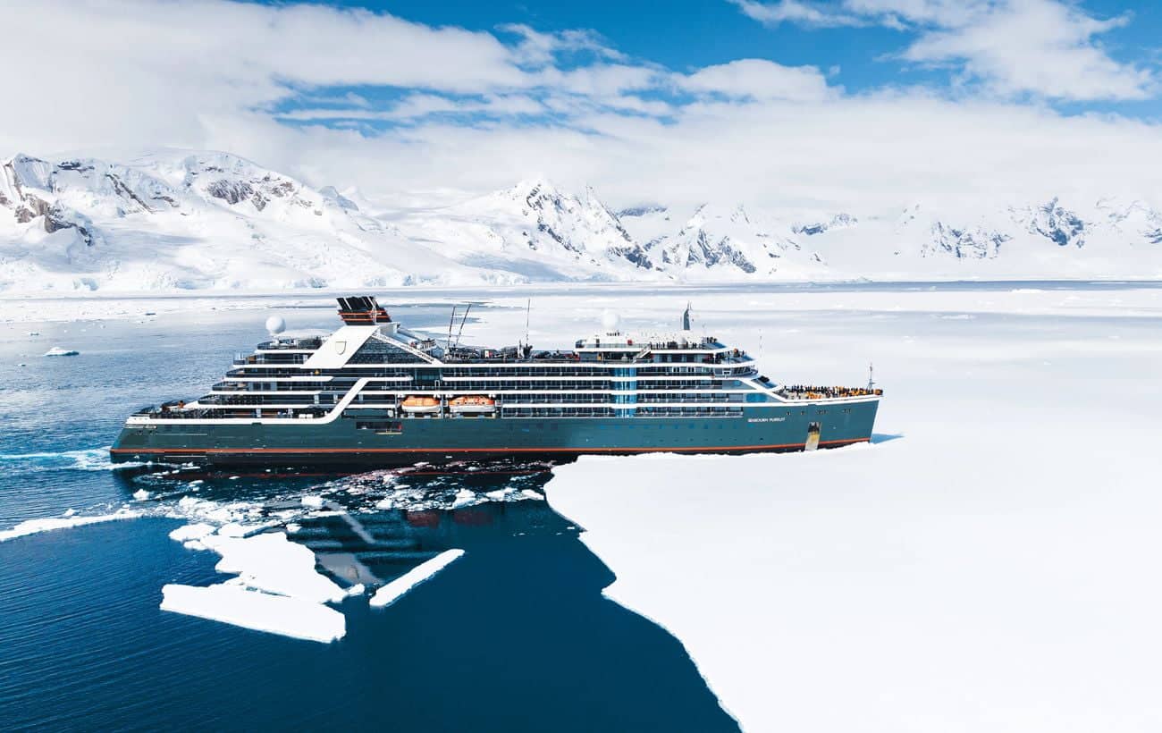 Seabourn Pursuit cruising beside Antarctic ice and snow-covered mountains