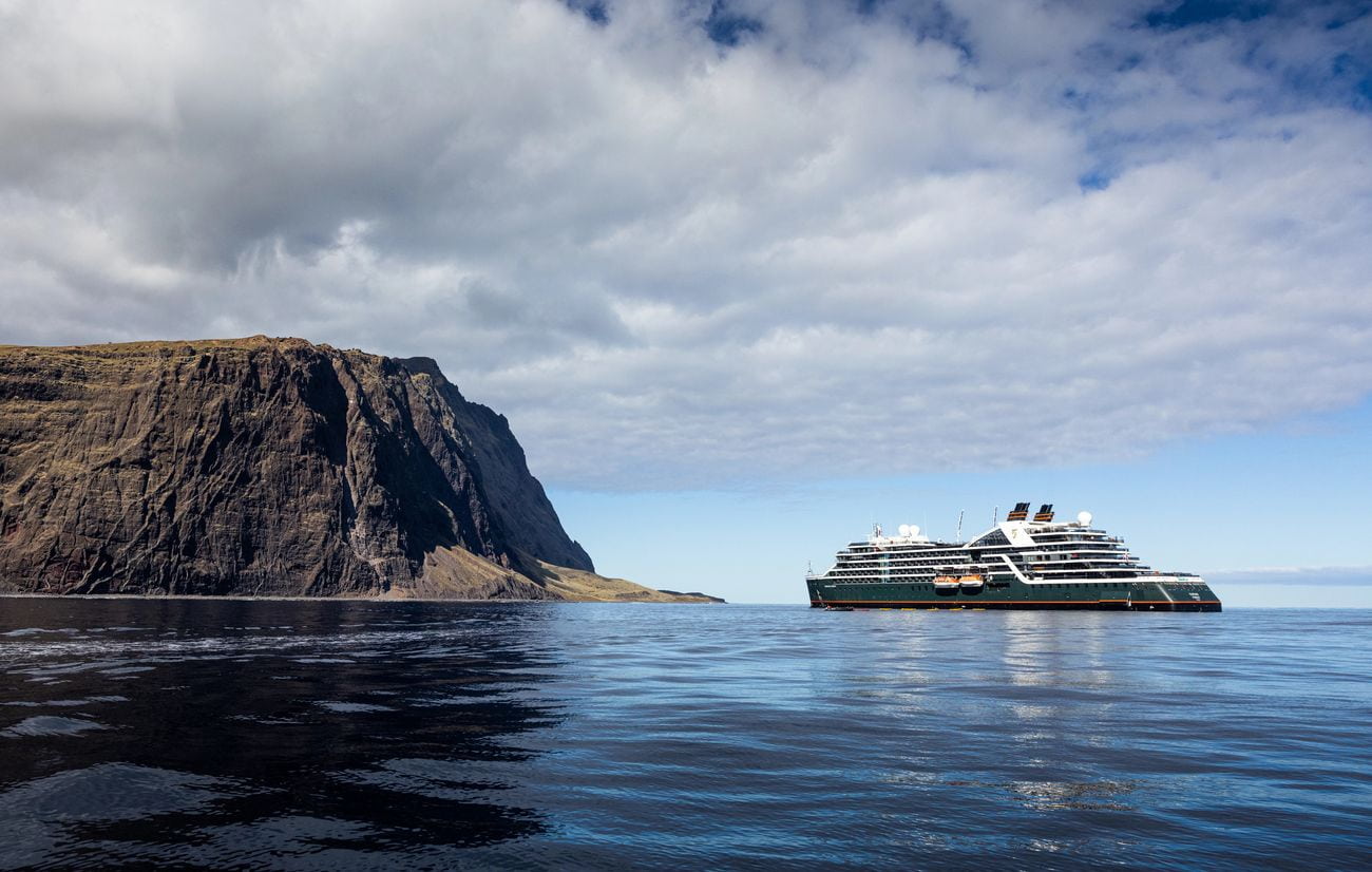 Expedition ship off Selkirk Island in Chile beside dramatic cliffs