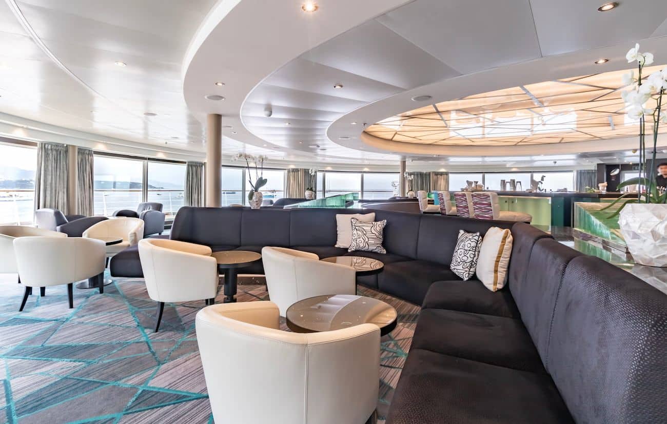 Observation Bar lounge with curved seating, ocean-facing windows, and soft contemporary seating