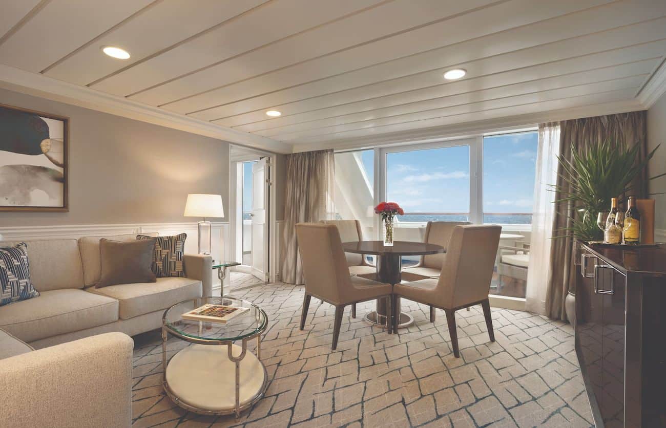 Oceania Insignia Owner’s Suite Living Room with sofa, dining area, and private veranda