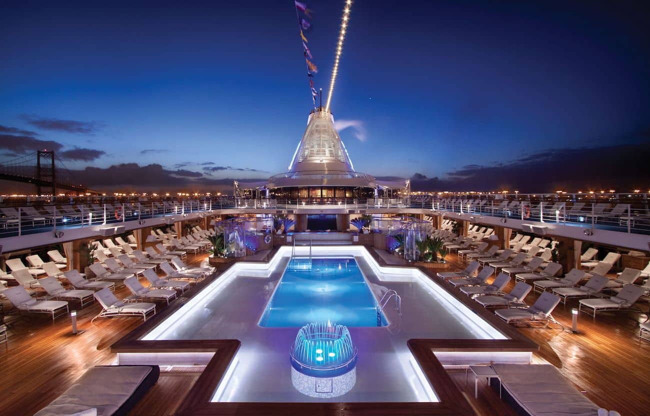 Oceania Marina Pool Deck illuminated at dusk with loungers and central pool