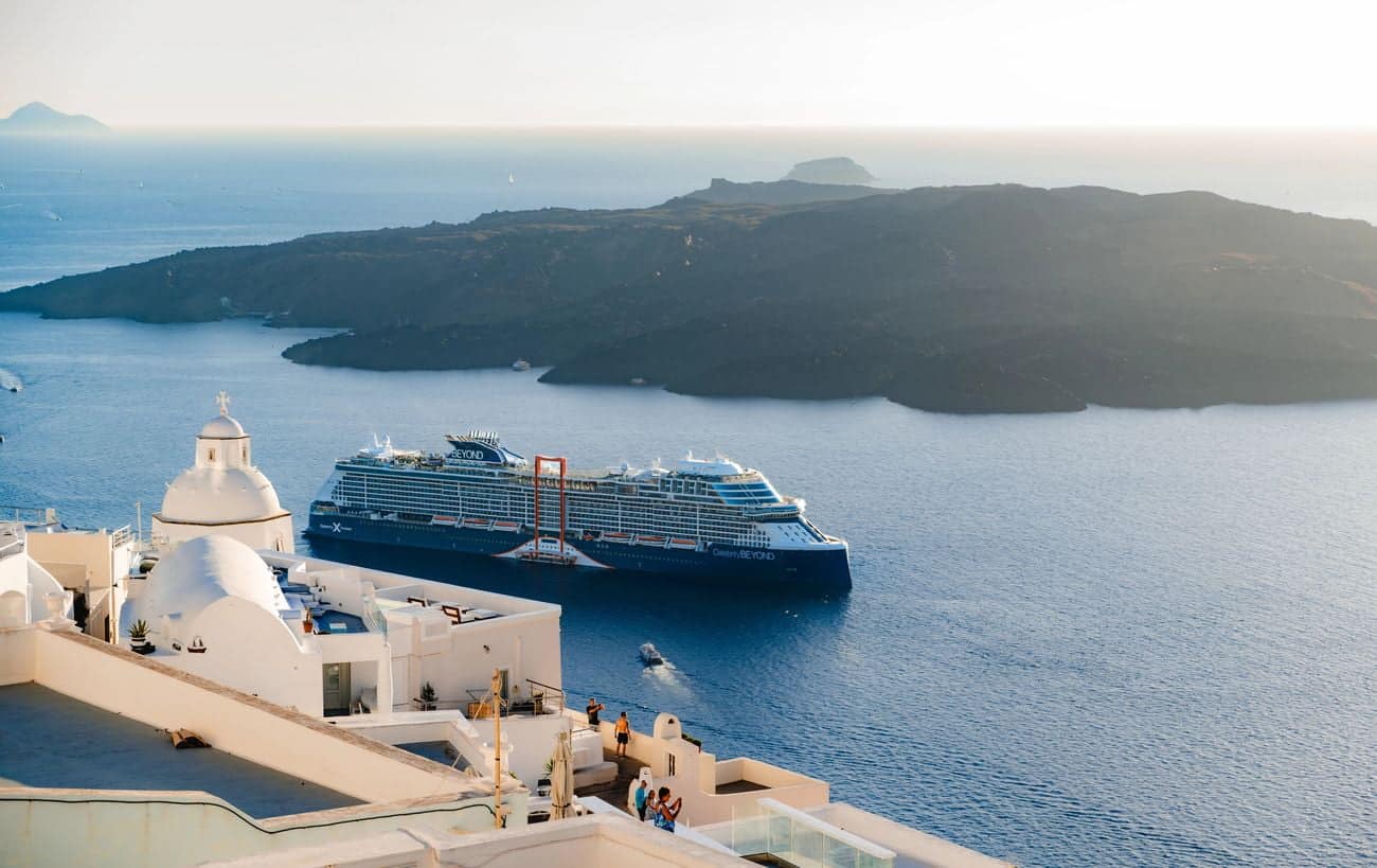 Celebrity Cruises ship sailing near Santorini cliffs