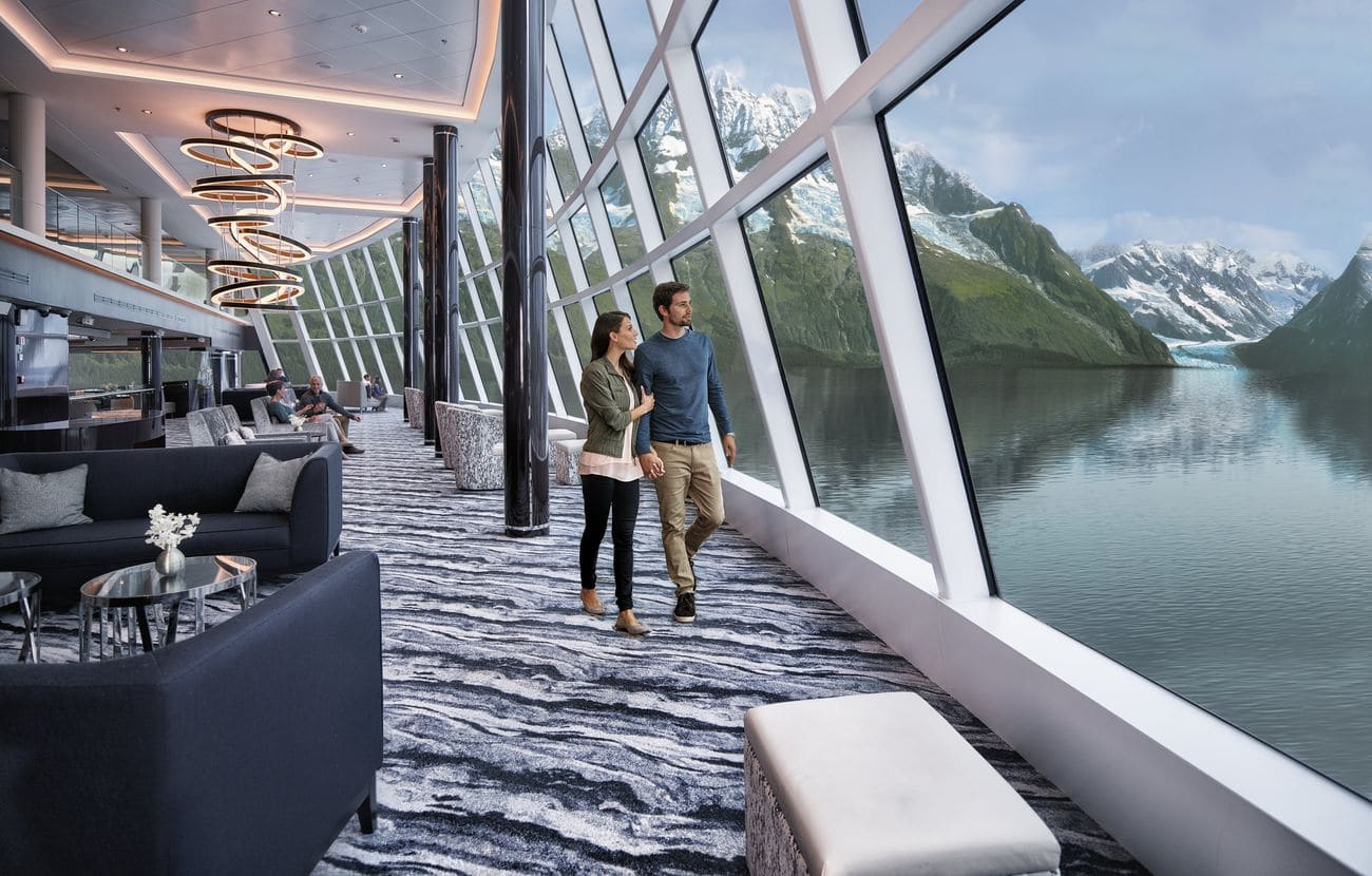 Guests walking through Norwegian Bliss Observation Lounge in Alaska