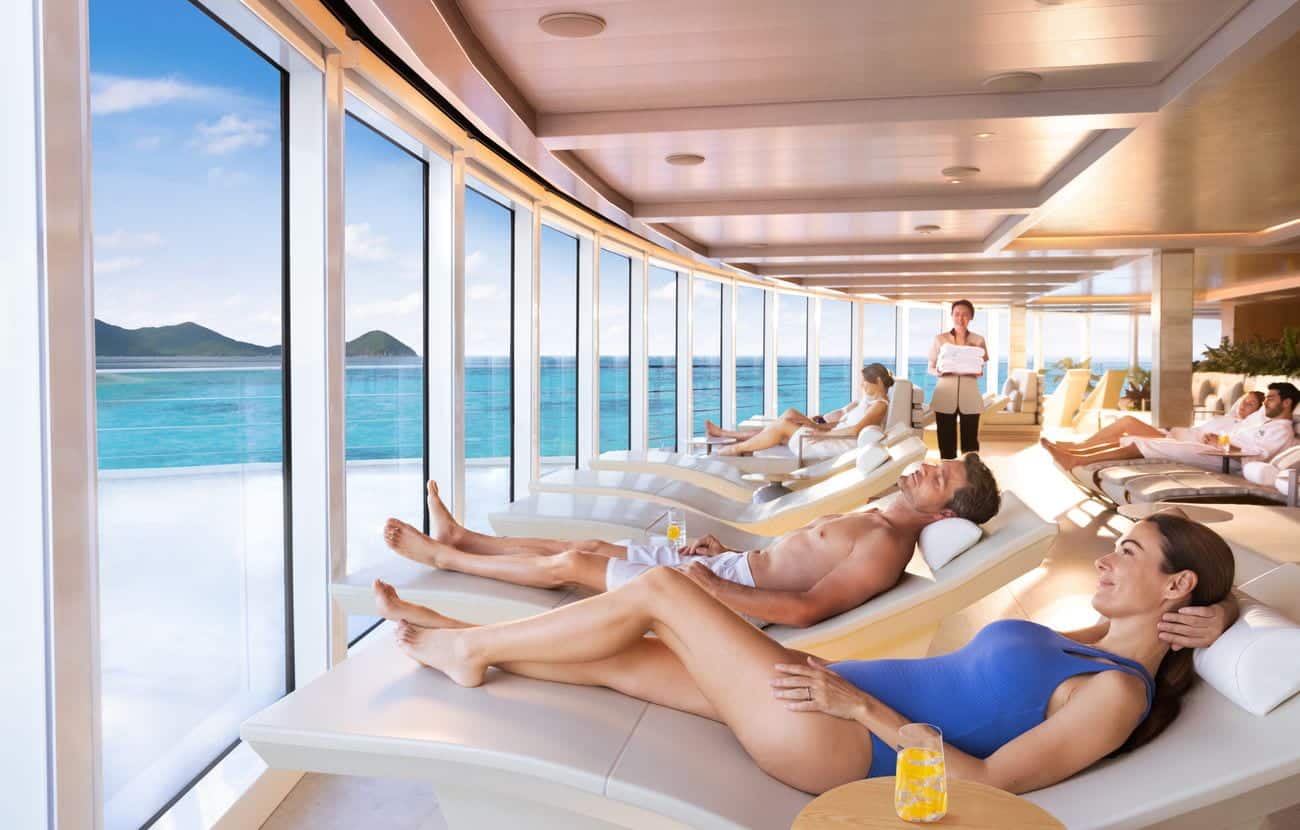 Guests relaxing on spa loungers with sea views