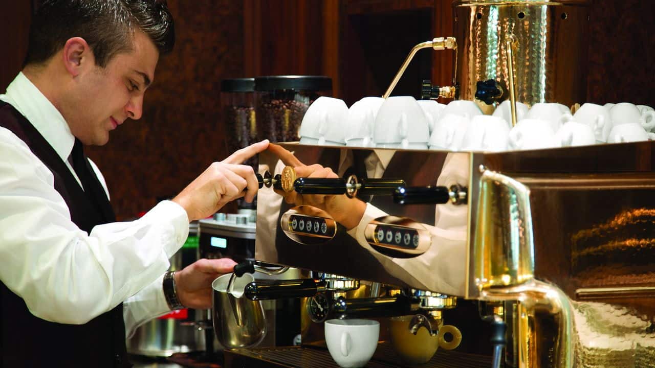Barista using espresso machine at Baristas