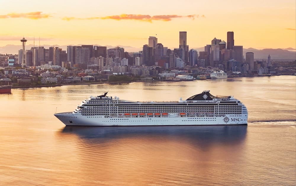 MSC Poesia passing the Seattle skyline during a golden dawn