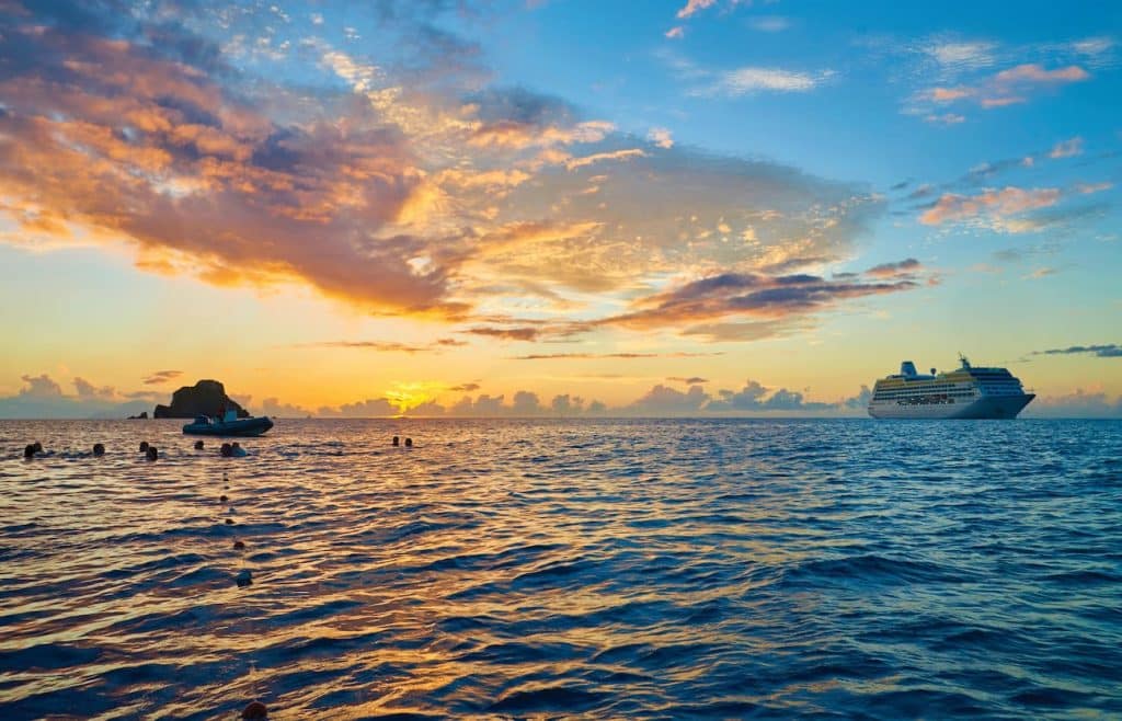 Oceania cruise ship off St. Barts at sunset with swimmers in the Caribbean Sea
