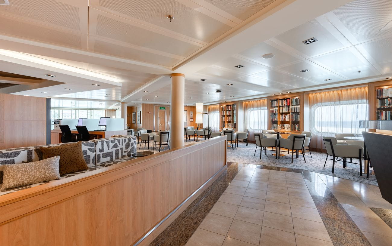 Seabourn Square aboard Seabourn Quest with lounge seating, bookshelves and service desks